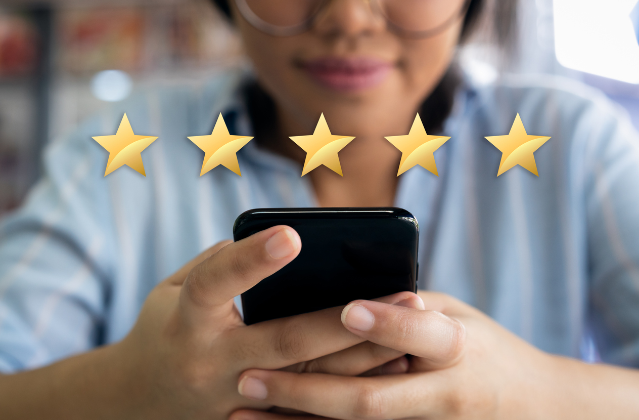 Woman using cell phone to leave a 5 star review